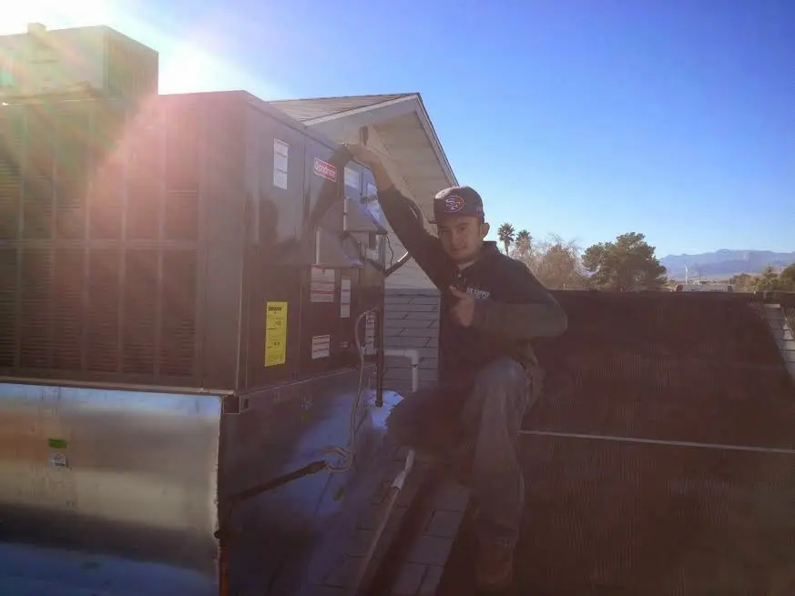 HVAC technician performing AC Tune-Up on a rooftop unit in Williamson